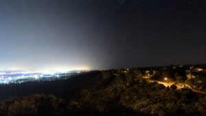 Night-sky scene illustrating a causal map separating skyglow, glare, trespass, clutter, ecological effects, and scalable interventions
