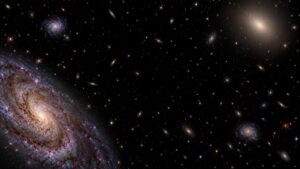 Artist's intergalactic view with comparable spiral and elliptical galaxies scattered around dark space, without a dominant central object.