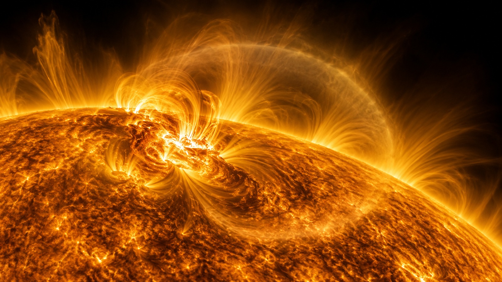 Scientific illustration of a broad coronal wavefront spreading from an active region across the Sun's luminous disk.